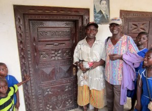 Mr. Bendu, left, of Moyeamoh village, proudly wears his Obama hat in front the Obama picture on his front porch. (He's holding the chicken I've been presented with.)
